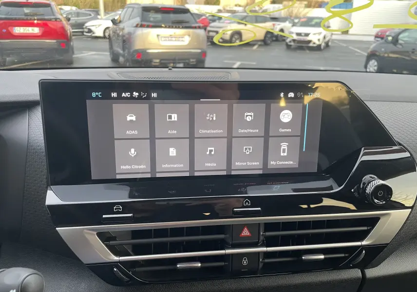 Vue intérieure centrée sur l'écran tactile du tableau de bord de la Citroën C4 hybride 2025, avec commandes visibles.
