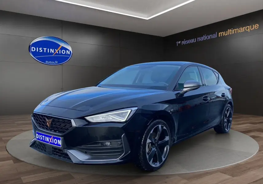 Vue 3/4 avant droite d'une CUPRA Leon noire 2023 avec jantes noires et calandre distinctive en showroom.
