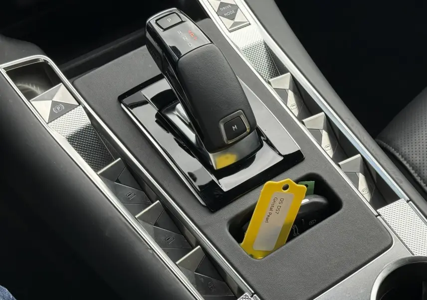 Gros plan sur la console centrale du DS7 2025 avec levier de boîte auto et clé avec étiquette Cristal Pearl.