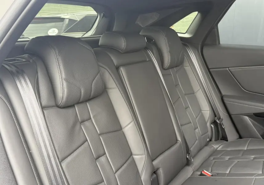 Vue intérieure de la banquette arrière en cuir noir Basalte du DS7 2025, avec ceintures de sécurité visibles.