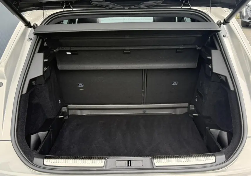 Coffre ouvert vu de l'arrière du DS7 Cristal Pearl 2025, intérieur noir avec hayon électrique et cache-bagages.