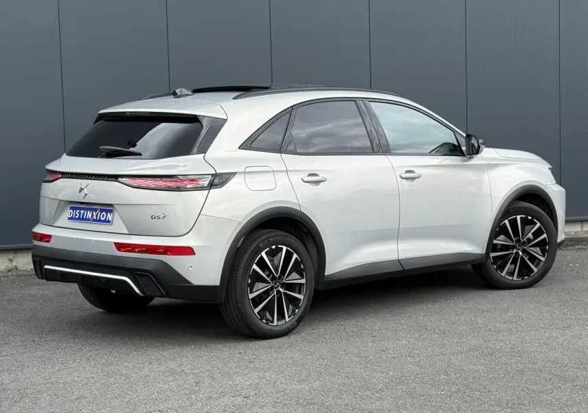 Vue 3/4 arrière droite d'un DS7 Cristal Pearl avec jantes alliage noires et toit ouvrant panoramique.