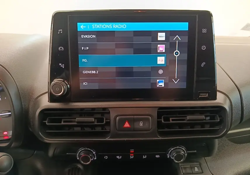 Écran tactile central affichant les stations radio dans l'habitacle du Citroën Berlingo blanc, vue de face.