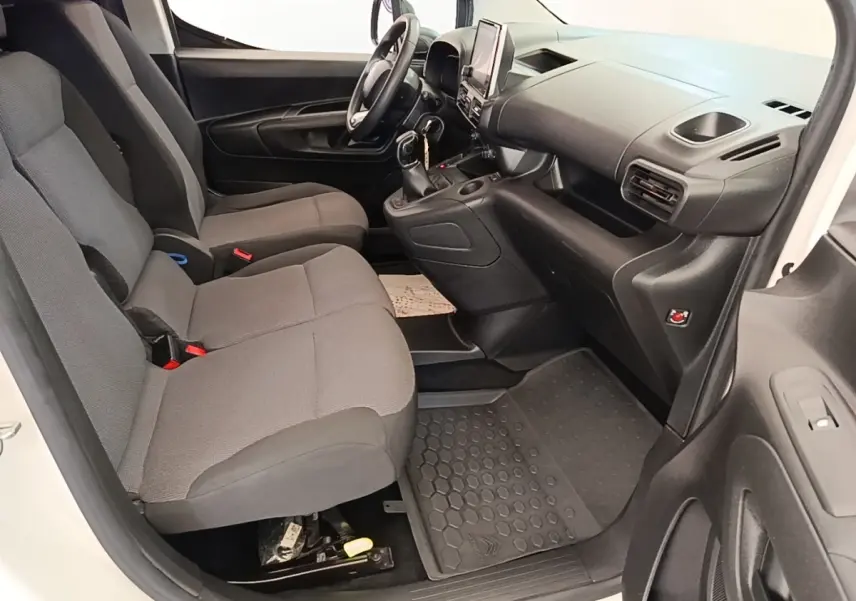 Vue intérieure côté conducteur du Citroën Berlingo blanc 2021, montrant sièges gris et tableau de bord avec écran tactile.