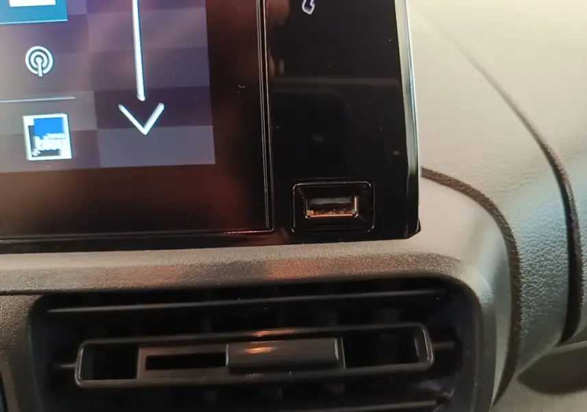 Gros plan sur la console centrale du Citroën Berlingo blanc, montrant un port USB à côté de l'écran tactile.