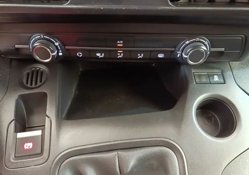 Vue rapprochée de la console centrale noire du Citroën Berlingo 2021 avec commandes climatisation et frein à main électrique.