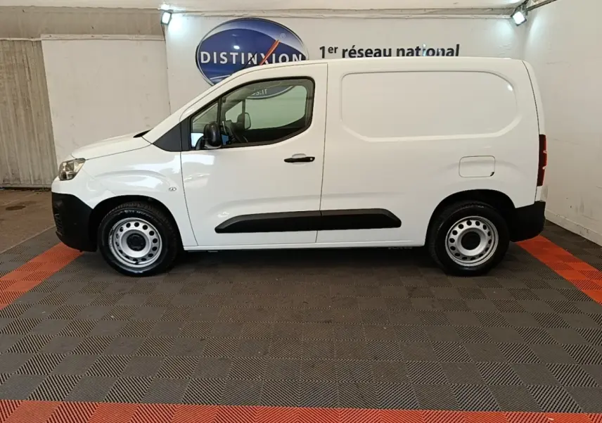 Vue de profil côté gauche d’un utilitaire Citroën Berlingo blanc avec jantes acier et protections latérales noires.