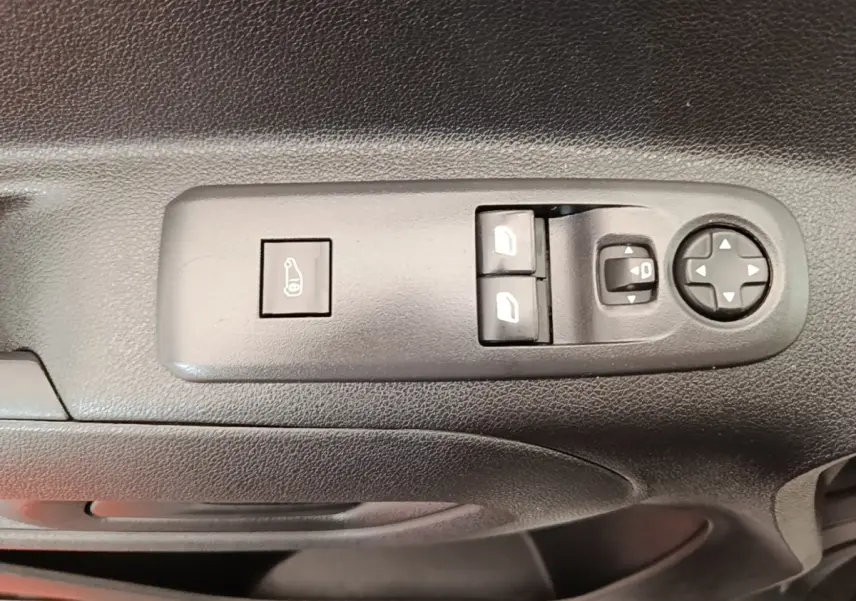 Gros plan sur les commandes de réglage des rétroviseurs et vitres électriques côté conducteur du Citroën Berlingo blanc.