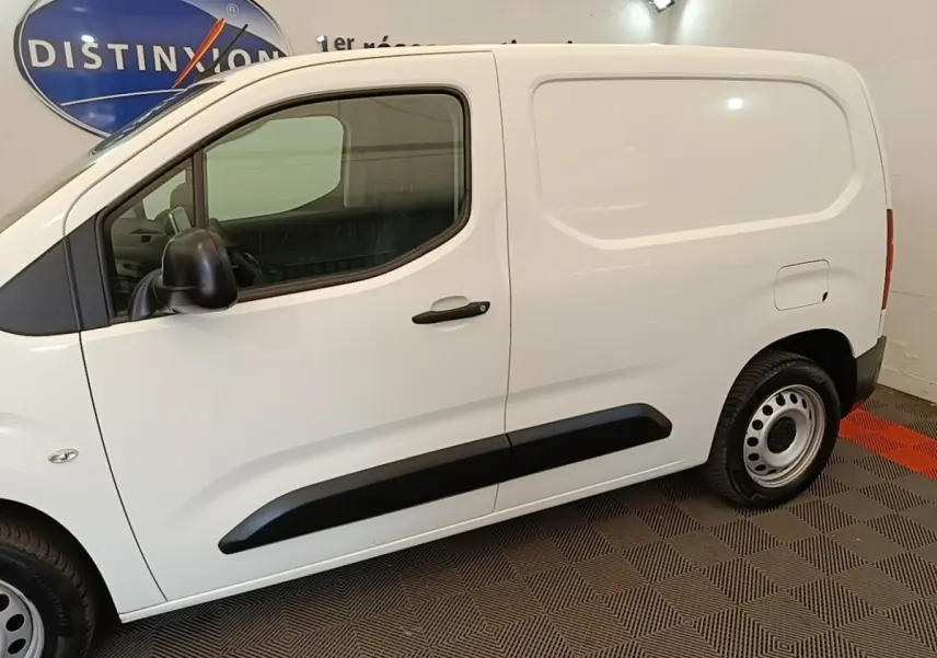 Vue latérale côté droit d’un utilitaire Citroën Berlingo blanc avec protections noires et jantes acier.