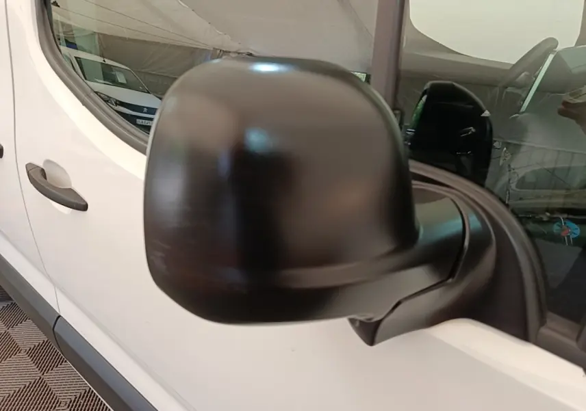 Rétroviseur noir en gros plan côté conducteur sur Citroën Berlingo blanc vue latérale partielle.