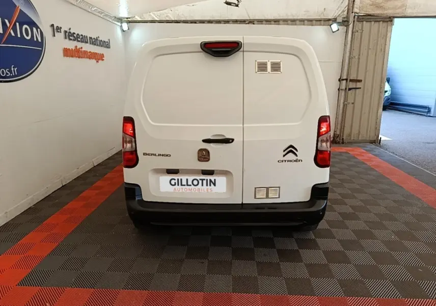 Vue arrière d’un utilitaire blanc Citroën Berlingo 2021 avec portes battantes et feux rouges allumés.
