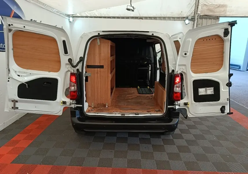 Vue arrière d’un utilitaire Citroën Berlingo blanc 2021 avec portes ouvertes et aménagements bois dans le coffre.