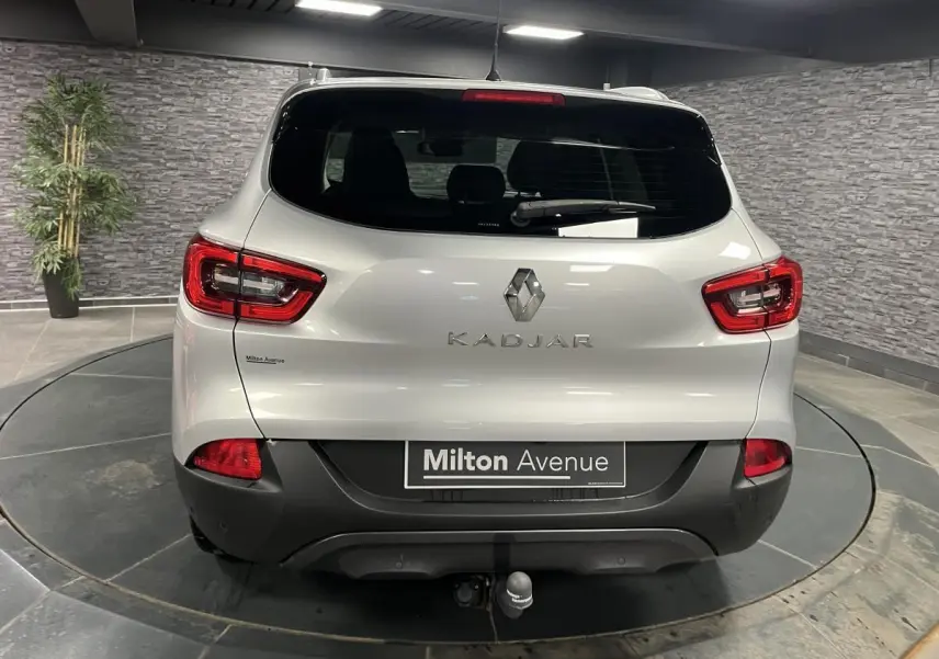 Vue arrière d'un Renault Kadjar gris avec attelage fixe et feux arrière LED dans un showroom.