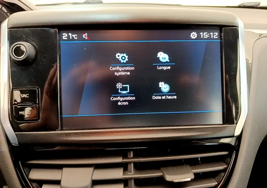 Écran tactile central affichant les réglages du système dans l'habitacle d'une Peugeot 208 Puretech blanche de 2019.