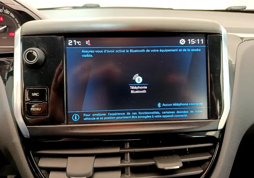 Écran tactile central affichant la connexion Bluetooth dans l’habitacle d’une Peugeot 208 blanche, vue de face.