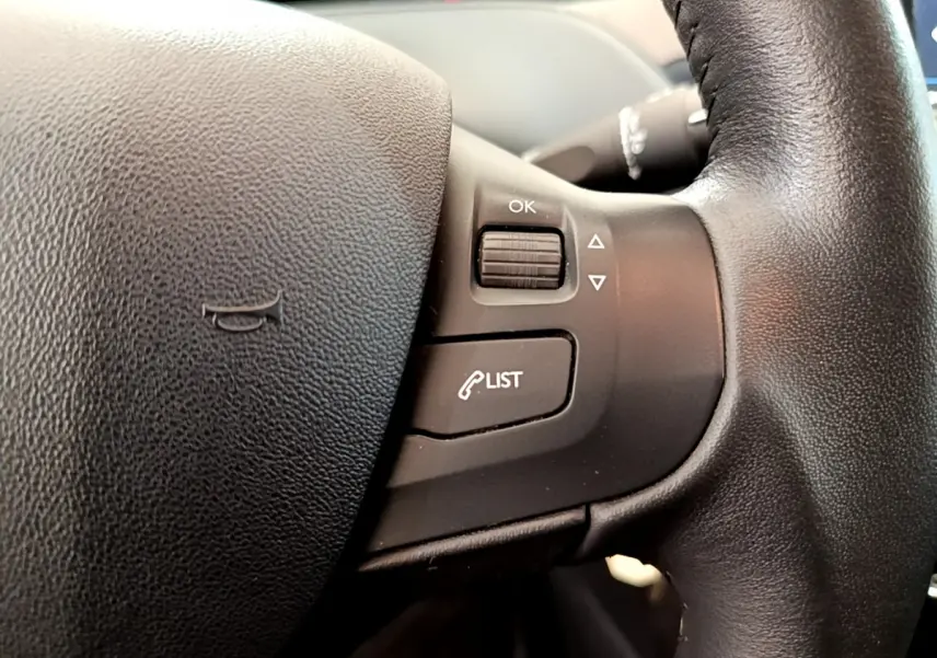 Gros plan sur les commandes du volant cuir noir de la Peugeot 208 Puretech 82 Signature 2019.