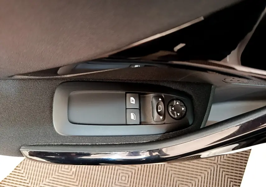 Commande des vitres électriques et réglage des rétroviseurs sur la porte côté conducteur d'une Peugeot 208 blanche