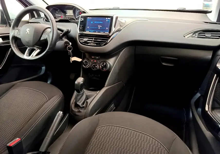 Intérieur avant de la Peugeot 208 Puretech 82 Signature 2019, montrant le tableau de bord et écran tactile central.