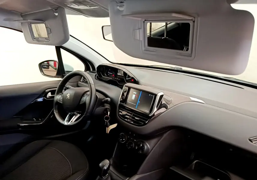 Vue intérieure côté conducteur du tableau de bord noir et volant cuir de la Peugeot 208 Puretech 82 Signature 2019.