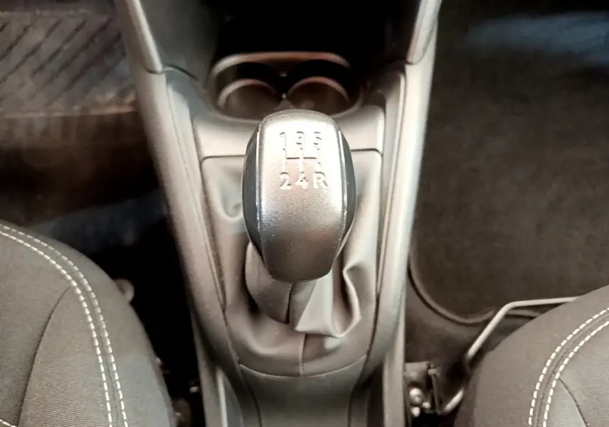 Le levier de vitesses manuel noir de la Peugeot 208 Puretech 82 Signature vu de dessus entre les sièges avant gris.