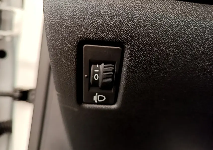Gros plan sur le réglage manuel des phares dans une Peugeot 208 Puretech 82 Signature blanche de 2019.