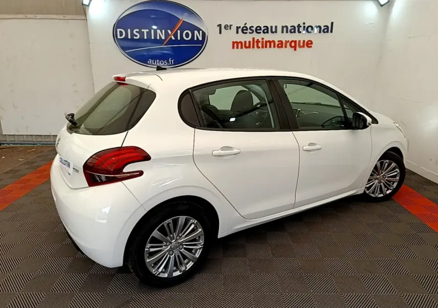 Peugeot 208 Puretech 82 Signature blanc vue de trois quarts arrière droit en intérieur showroom.