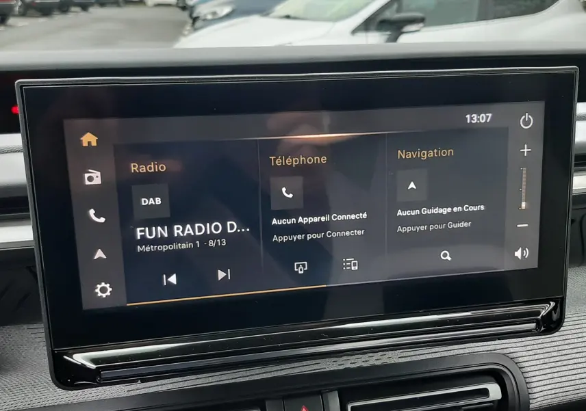 Écran tactile central du tableau de bord du Citroën C3 Aircross hybride 2025, avec interface radio, téléphone et navigation.