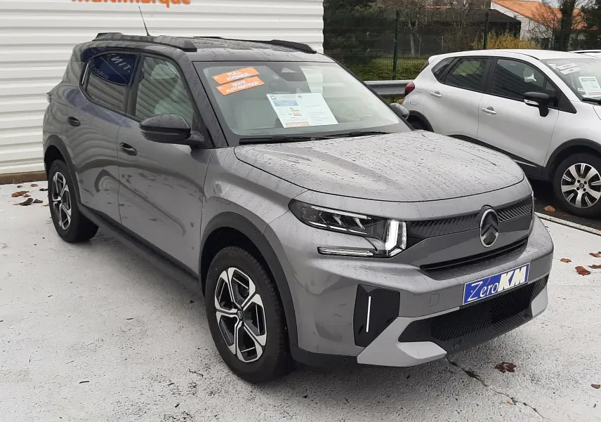 Citroën C3 Aircross hybride gris avec toit noir, vue 3/4 avant droit sous la pluie, jantes bi-ton distinctives.