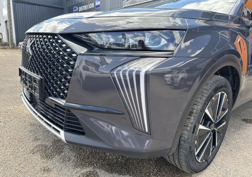 Gros plan sur l'avant droit du DS7 2025 Vol de Nuit, mettant en valeur la calandre distinctive et les phares LED.