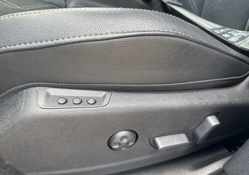Gros plan sur les commandes de réglage électrique du siège conducteur en cuir noir du DS7 Vol de Nuit.