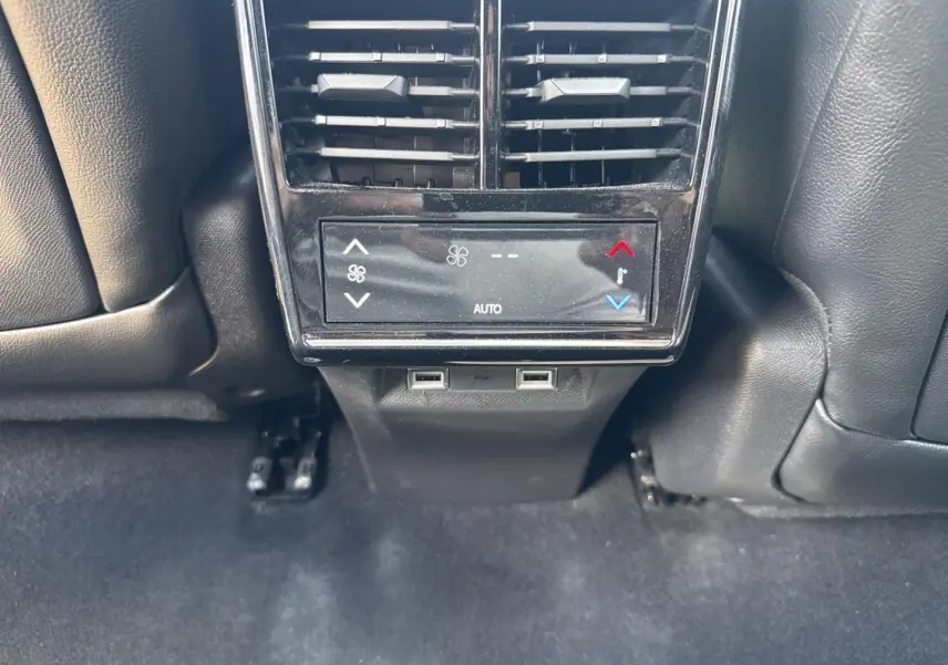 Vue rapprochée de la console arrière noire avec bouches d’aération et commandes climatisation du DS7 Vol de Nuit.
