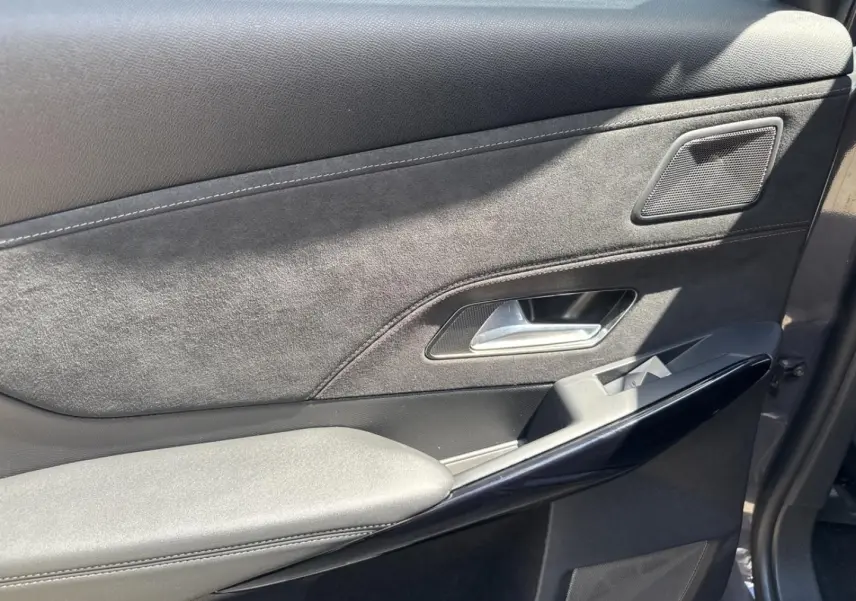 Gros plan sur la porte avant droite du DS7 2025 Vol de Nuit, avec habillage Alcantara noir et insert brillant noir.