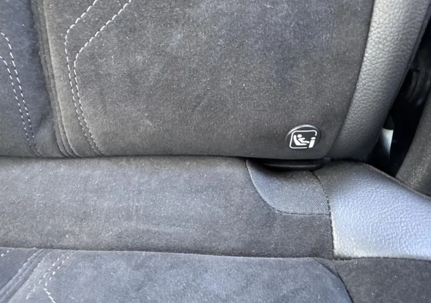 Gros plan sur la banquette arrière en Alcantara noir profond avec logo Isofix visible sur DS7 Vol de Nuit.