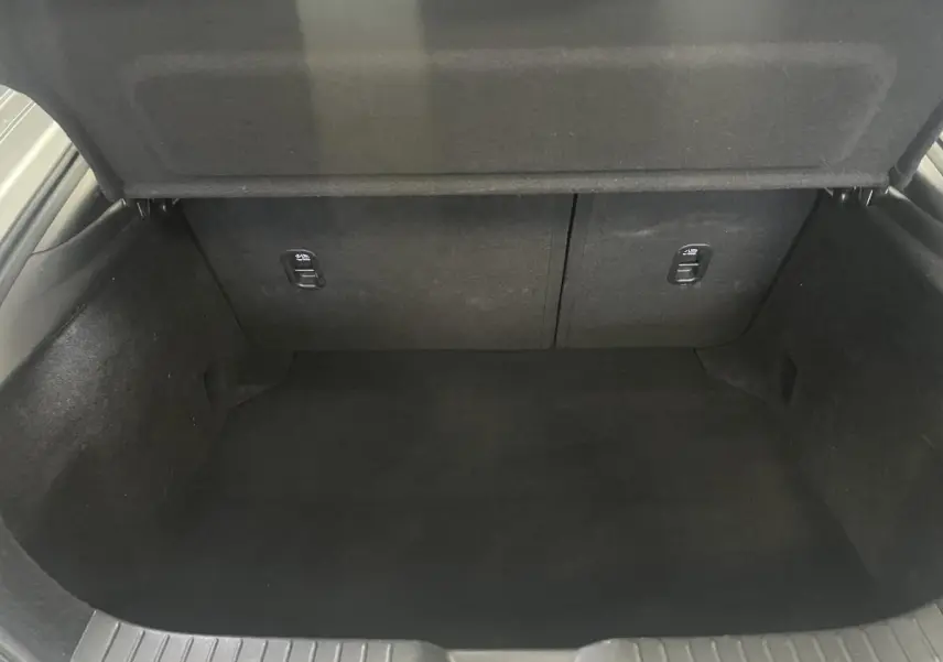 Coffre vide de la Mazda3 2.0 e-Skyactiv-G M-Hybrid gris, vue intérieure arrière avec habillage noir.