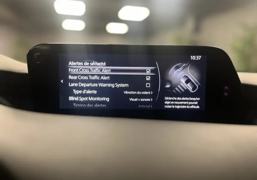 Écran central de la Mazda3 2023 affichant les alertes de sécurité avec interface moderne et lisible.