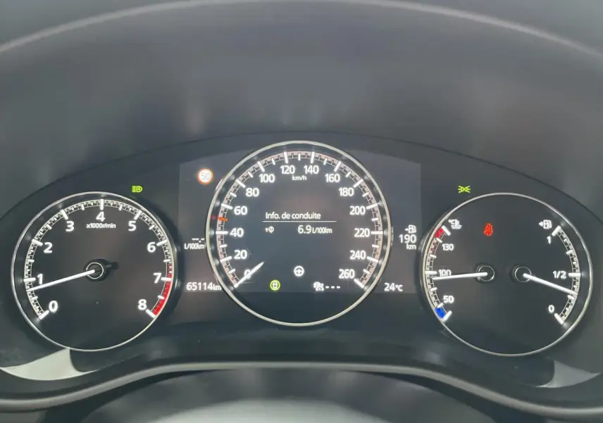 Tableau de bord de Mazda3 2023 avec compte-tours, compteur de vitesse et jauge, affichage digital central.