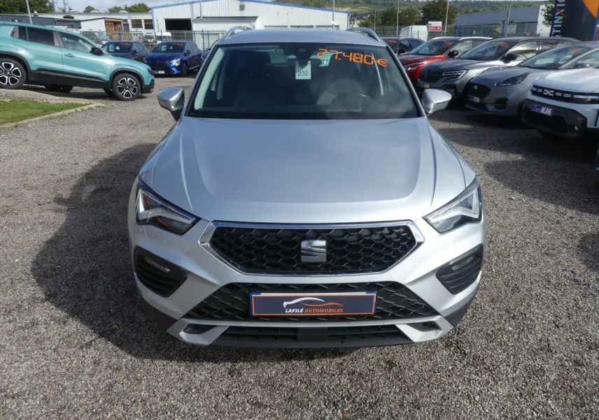 Vue frontale d'un SEAT Ateca gris clair 2023 avec calandre noire et plaques du concessionnaire visible.
