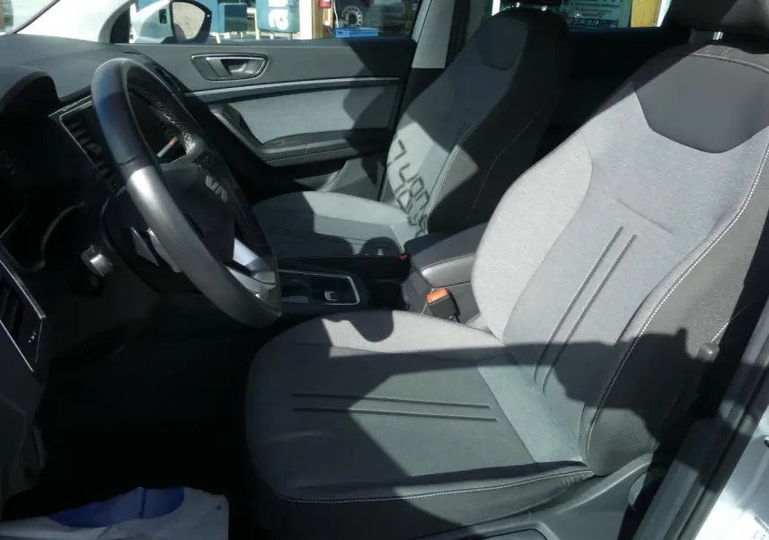 Intérieur avant droit du SEAT Ateca 2023 avec sièges textile gris clair et volant cuir multifonctions.