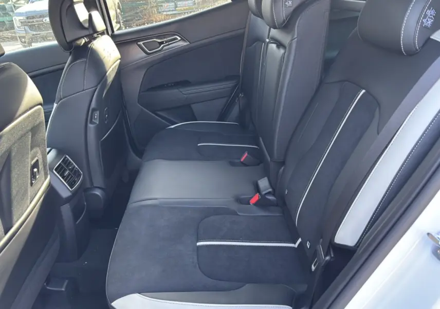 Vue intérieure côté droit sur la banquette arrière noire et grise du Kia Sportage 2026 blanc nacré toit noir.