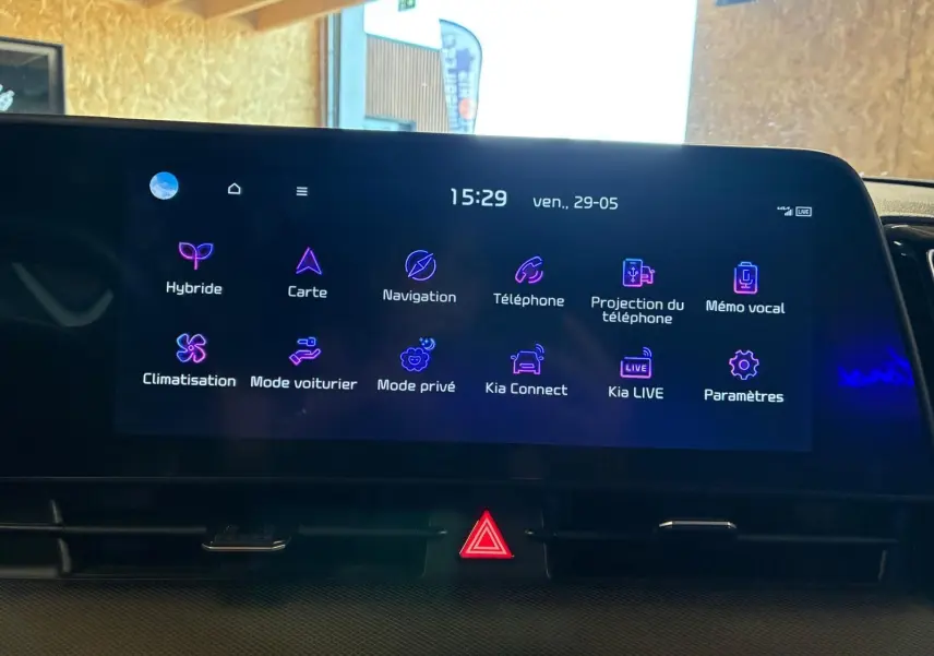 Écran tactile central du Kia Sportage hybride 2024 affichant les options de navigation et connectivité, vue de face en intérieur.