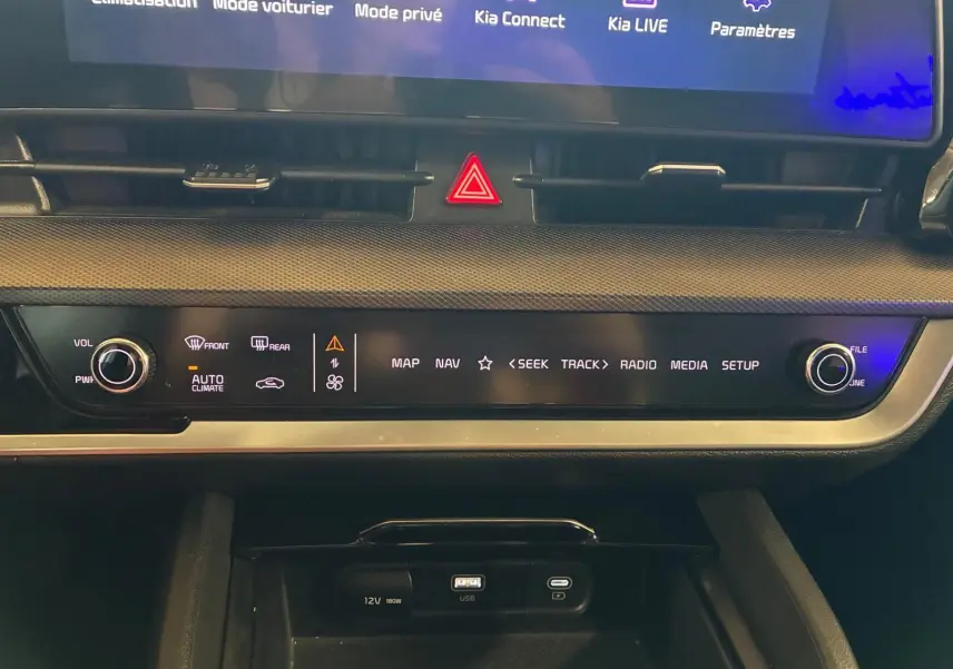 Vue rapprochée de la console centrale du Kia Sportage gris 2024, affichant les commandes multimédia et climatisation.