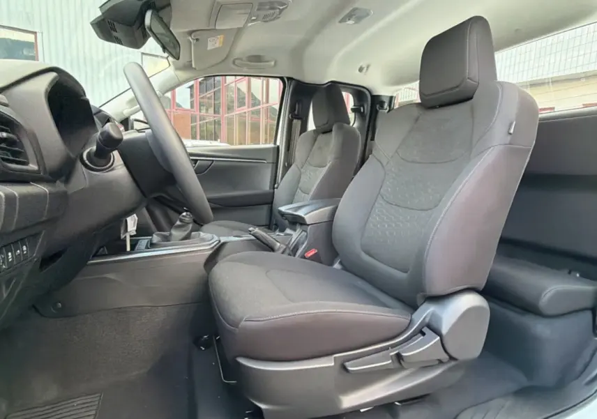 Vue intérieure côté conducteur des sièges avant en tissu gris avec accoudoir central du pick-up Isuzu D-MAX 2026 Splash White.