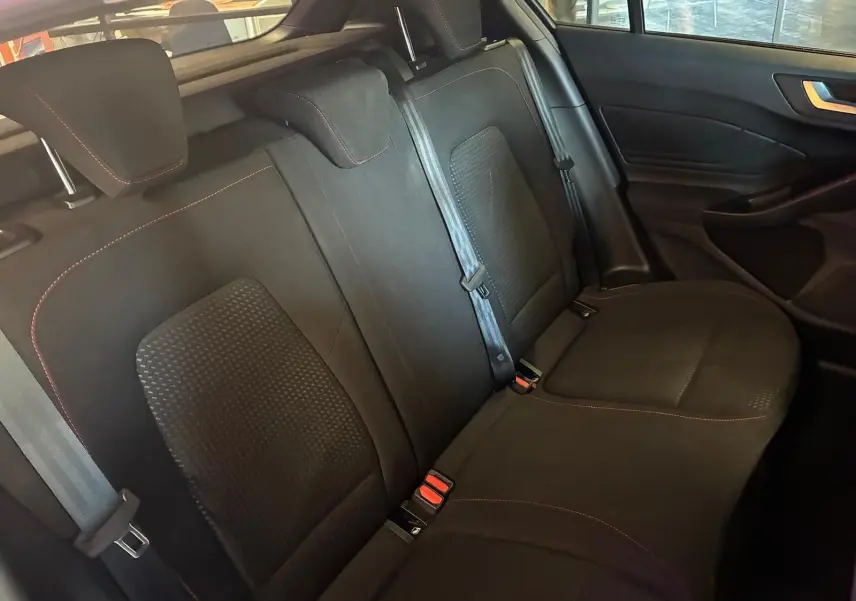 Vue intérieure des sièges arrière en tissu noir avec surpiqûres rouges de la Ford Focus 2024, version ST Line.