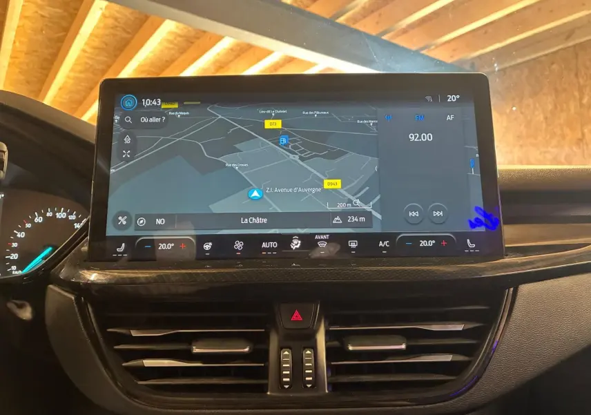 Écran tactile central avec navigation et commandes climatisation dans l’habitacle noir d’une Ford Focus bleue 2024.