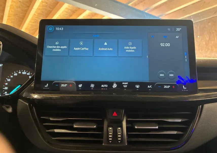 Vue intérieure centrée sur l'écran tactile du tableau de bord de la Ford Focus 2024, affichant les options multimédia et climatisation.