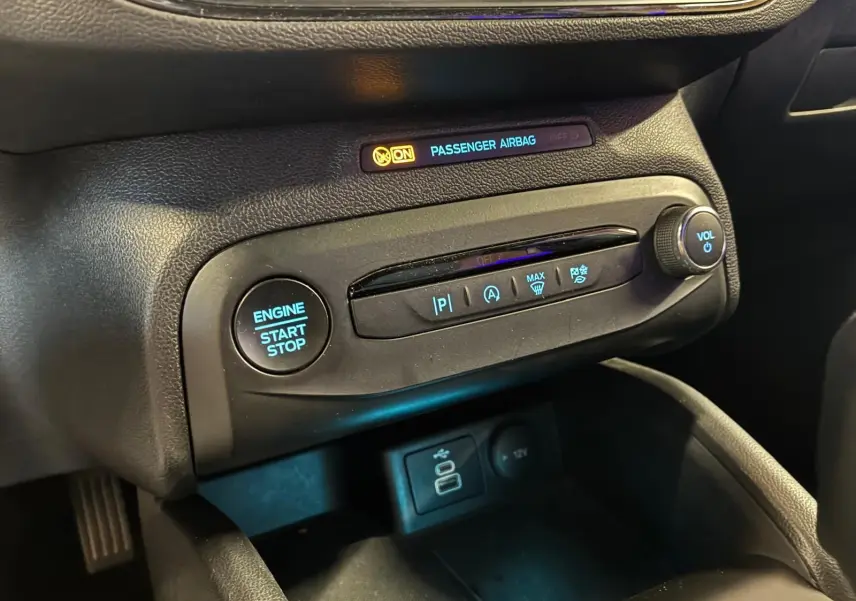 Détail du tableau de bord noir de la Ford Focus 2024 avec bouton start/stop et commandes climatisation visibles.