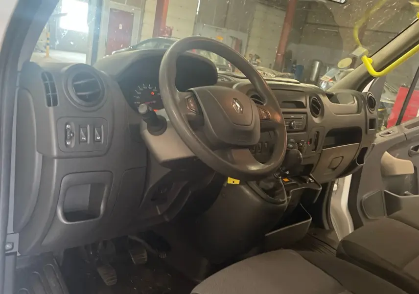Vue intérieure côté conducteur du Renault Master blanc 2019, montrant le tableau de bord et le volant.