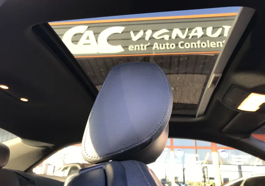 Gros plan sur l'appuie-tête en cuir noir de l'Audi A5 Coupé 2012, avec toit ouvrant panoramique visible en arrière-plan.