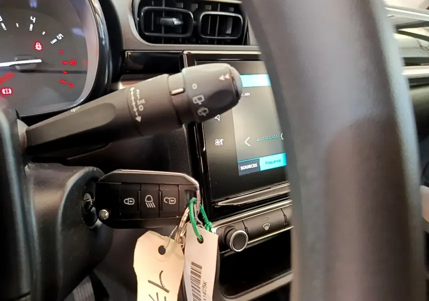 Vue rapprochée du tableau de bord et du volant de la Citroën C3 2019 avec clé insérée et écran tactile allumé.