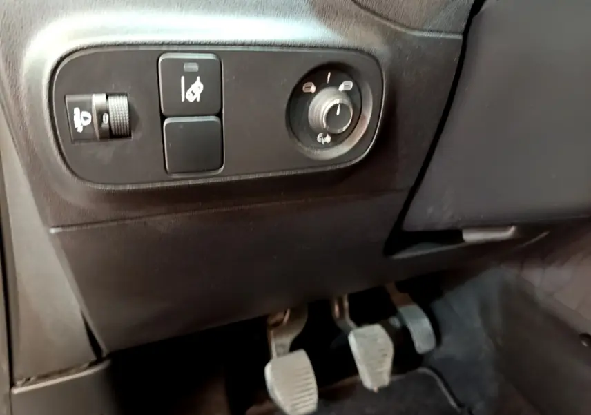 Vue intérieure côté gauche montrant les commandes des rétroviseurs et les pédales d'une Citroën C3 blanche PureTech 2019.